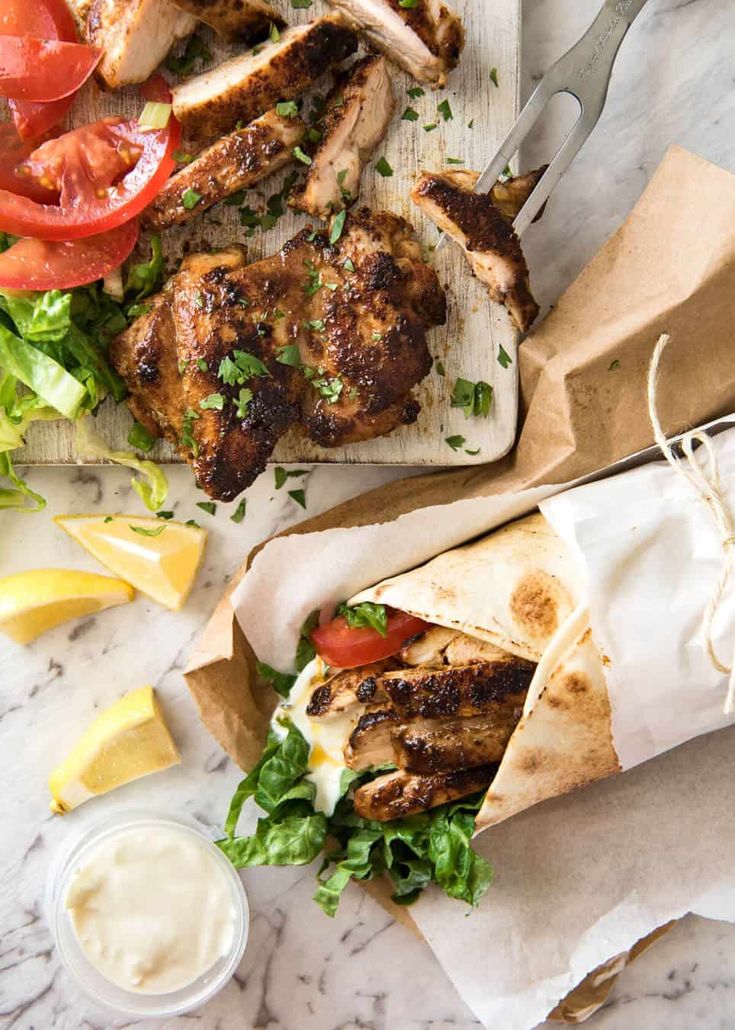 the instagram page shows an image of chicken shawarma with lettuce, tomatoes and lemon wedges