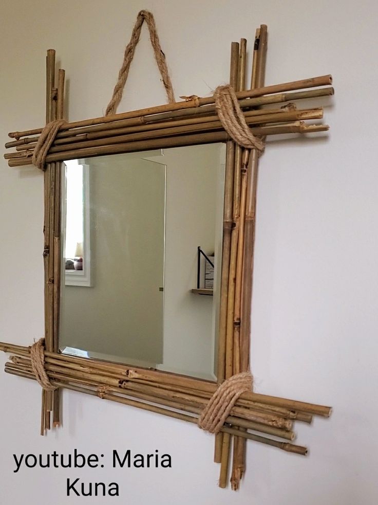 a mirror made out of bamboo sticks hanging on the wall next to a sink in a bathroom