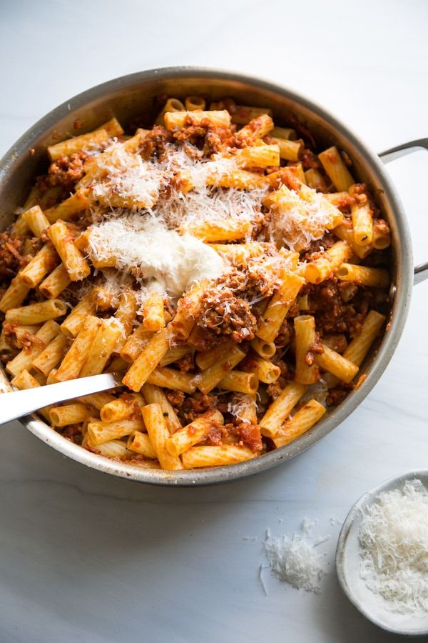 a pot filled with pasta and sauce on top of a table