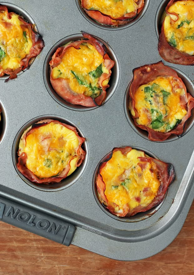 an open muffin tin filled with breakfast foods