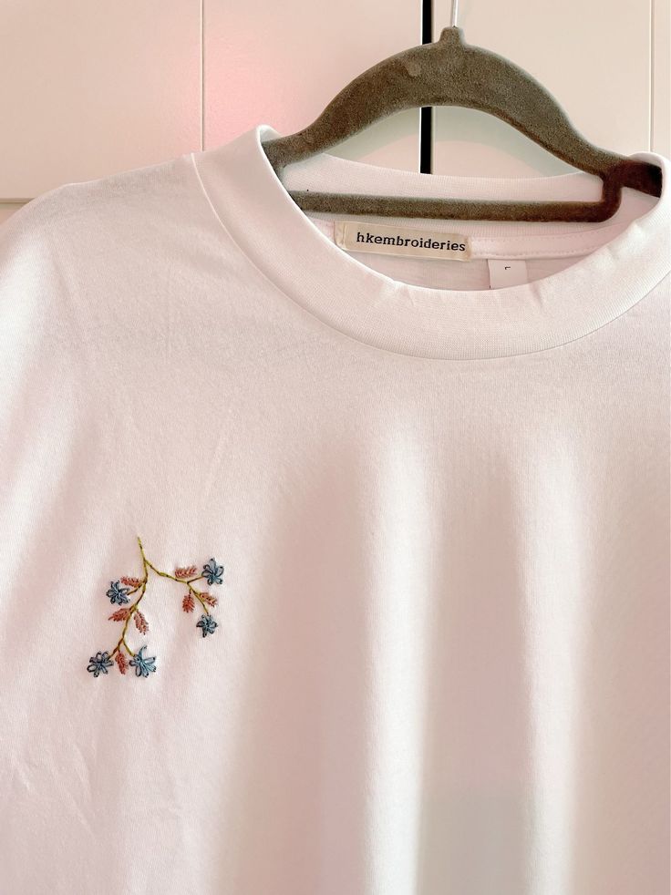 Flowers on branch embroidered t-shirt White Tops With Embroidered Logo For Spring, Spring Short Sleeve Tops With Contrast Embroidery, Spring Tops With Contrast Embroidery And Short Sleeves, Short Sleeve Tops With Contrast Embroidery For Spring, White Crew Neck T-shirt With Floral Embroidery, White T-shirt With Embroidered Text For Fall, White T-shirt With Embroidered Logo For Spring, Embroidered White T-shirt For Fall, White Shirt With Embroidered Text For Spring