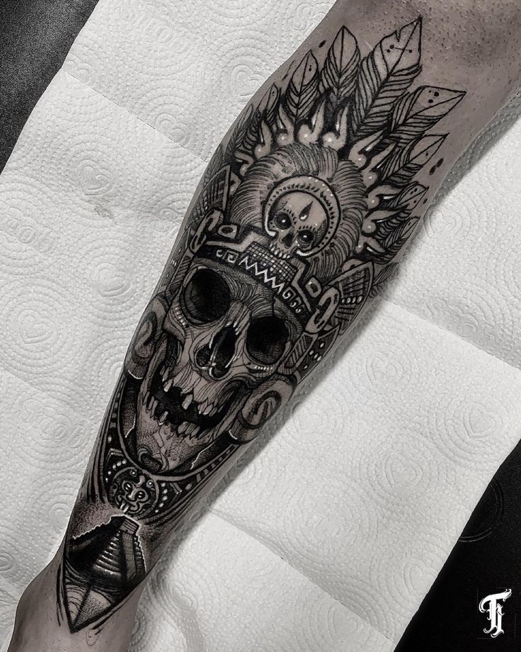 a man's leg with a skull and sunflowers tattoo on his arm