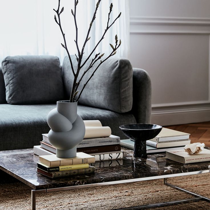 a coffee table with books and a vase on it