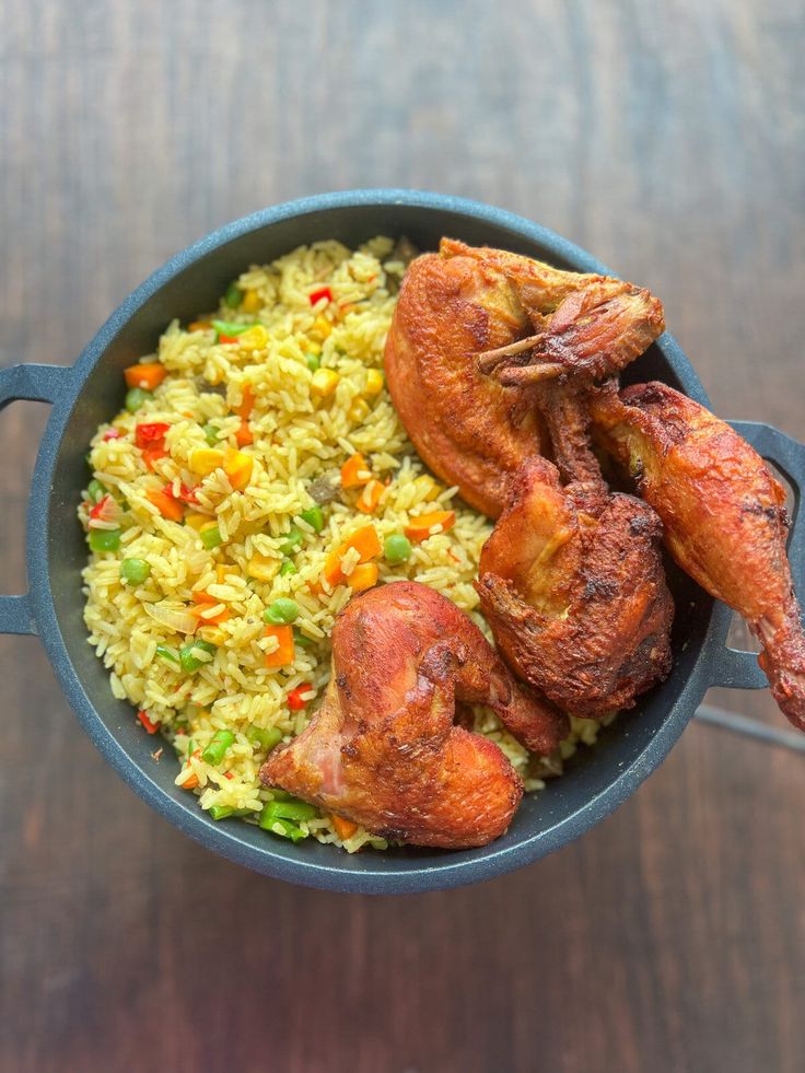 chicken and rice in a pan on a wooden table