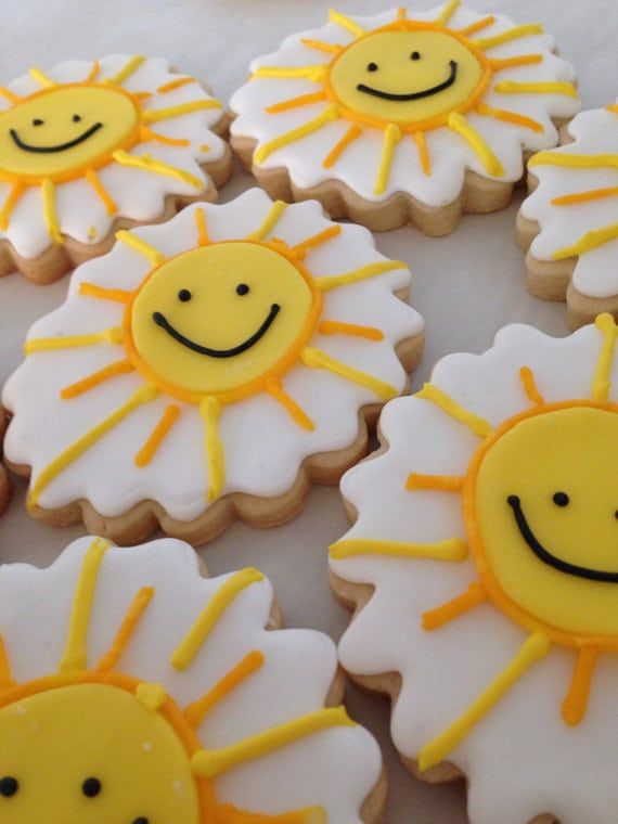 decorated cookies with yellow and white frosting depicting sunflowers, smiling faces on them