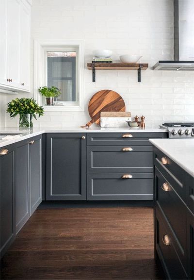 a kitchen with gray cabinets and white counter tops