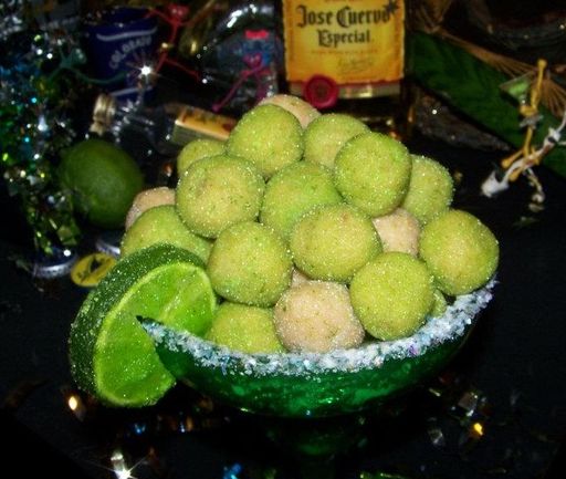 a green bowl filled with lots of food on top of a table next to bottles