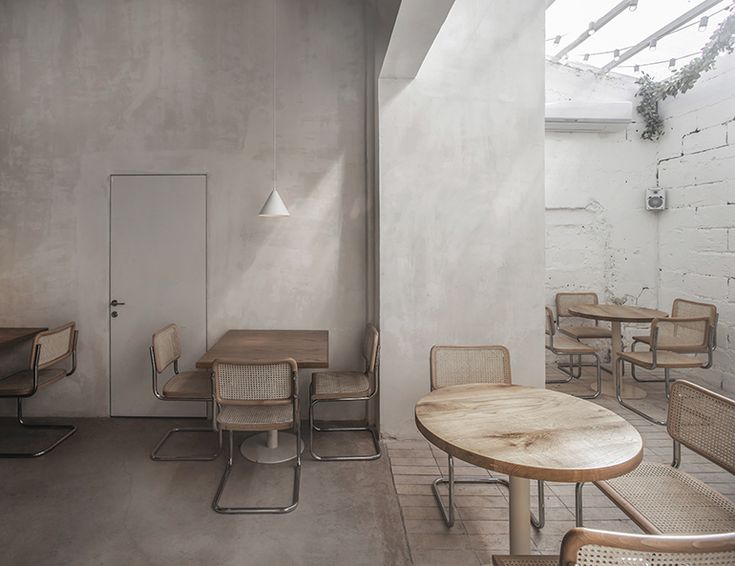 an empty room with wooden tables and chairs