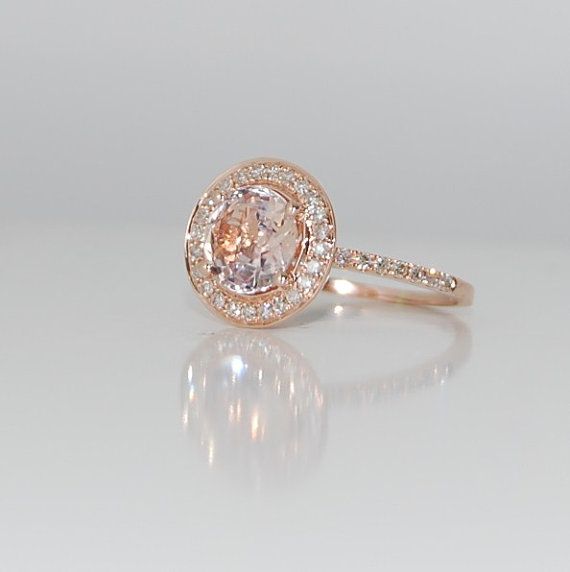 an engagement ring with a pink diamond in the center and white diamonds on the sides