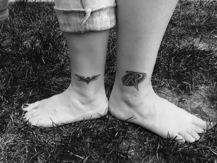 two people with tattoos on their feet standing next to each other, one has the letter r