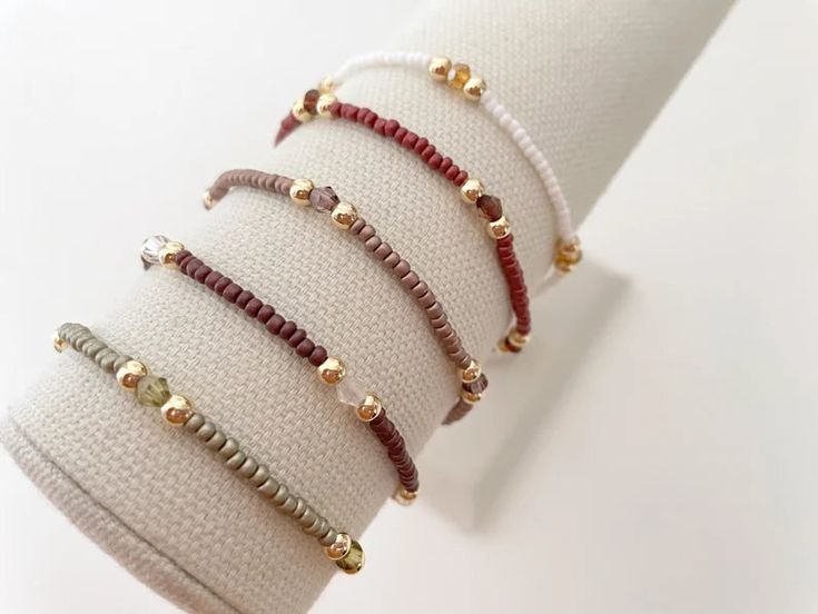 one seed bead stacking bracelet with 14k gold accent beads bracelets are made on a durable stretch elastic cord please refer to our sizing guide before purchasing Everyday Stackable Rondelle Beaded Bracelets, Adjustable Stackable Beaded Bracelets For Layering, Adjustable Gold Beads Rondelle Bracelets, Minimalist Stretch Bracelet With Round Beads For Everyday, Minimalist Stretch Bracelet With Round Beads, Adjustable Gold Beaded Rondelle Bracelets, Adjustable Rondelle Bracelets For Everyday, Minimalist Everyday Stretch Bracelet With Round Beads, Minimalist Hand-strung Stretch Bracelet For Everyday