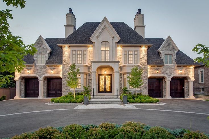 a large house with two garages and lights on the front