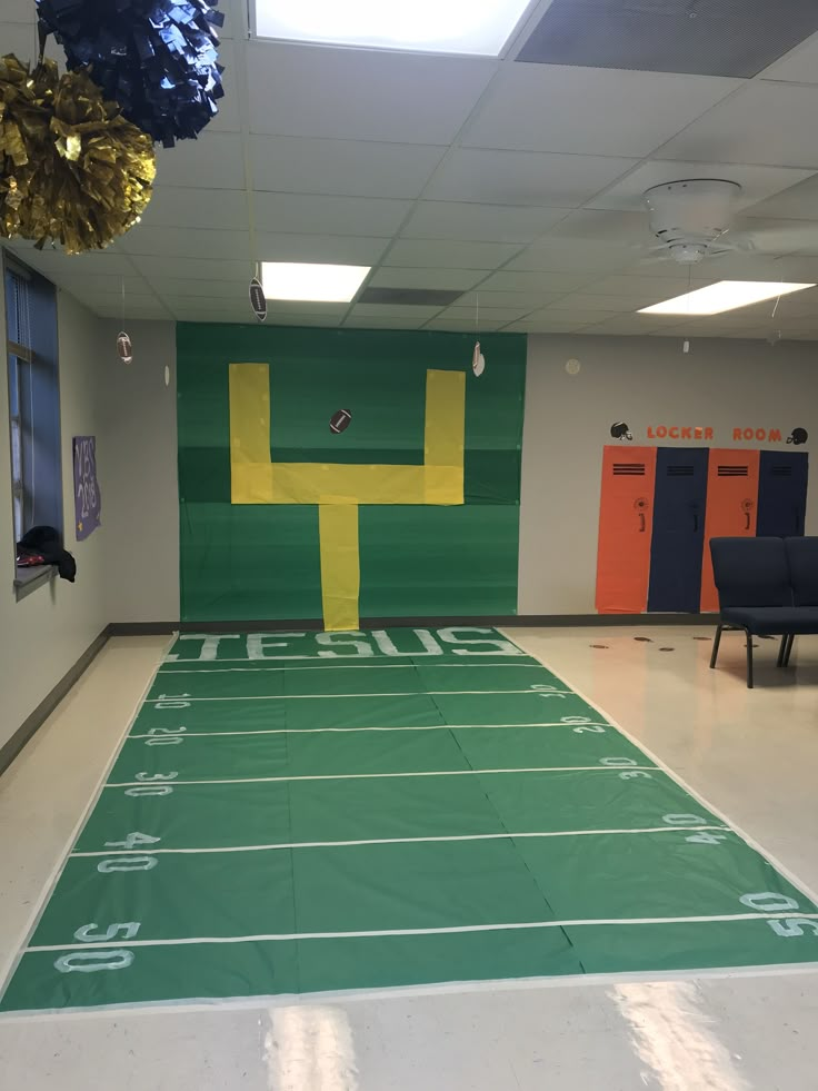 an indoor football field is painted green and yellow