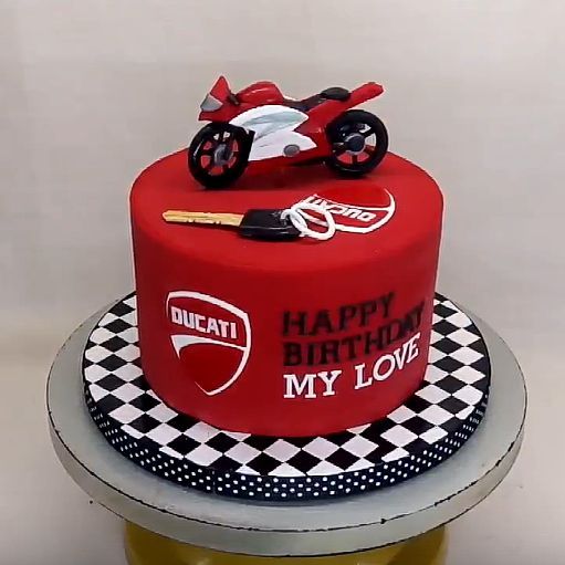 a red birthday cake with a motorcycle on top