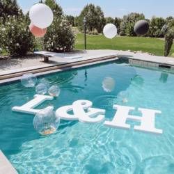 balloons floating in the air over a pool with an h & m sign on it