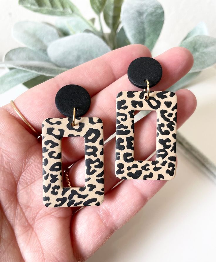 a pair of leopard print and black acrylic earrings in the shape of a rectangle