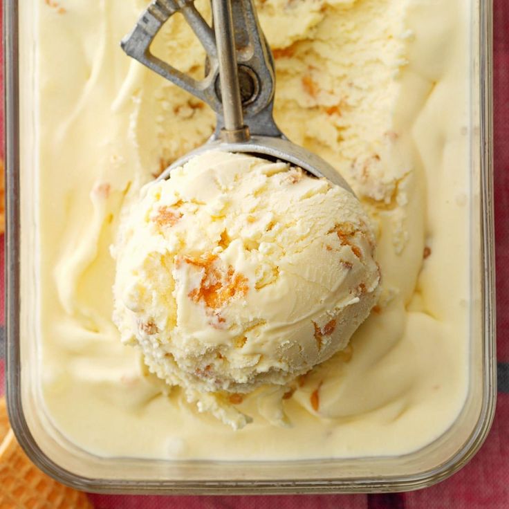 two scoops of ice cream in a plastic container with an orange and white checkered table cloth