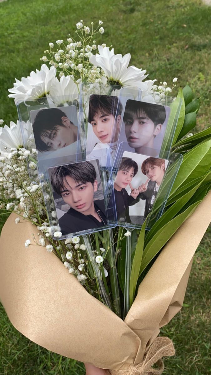 a bunch of flowers that are sitting in the grass with some pictures on top of them