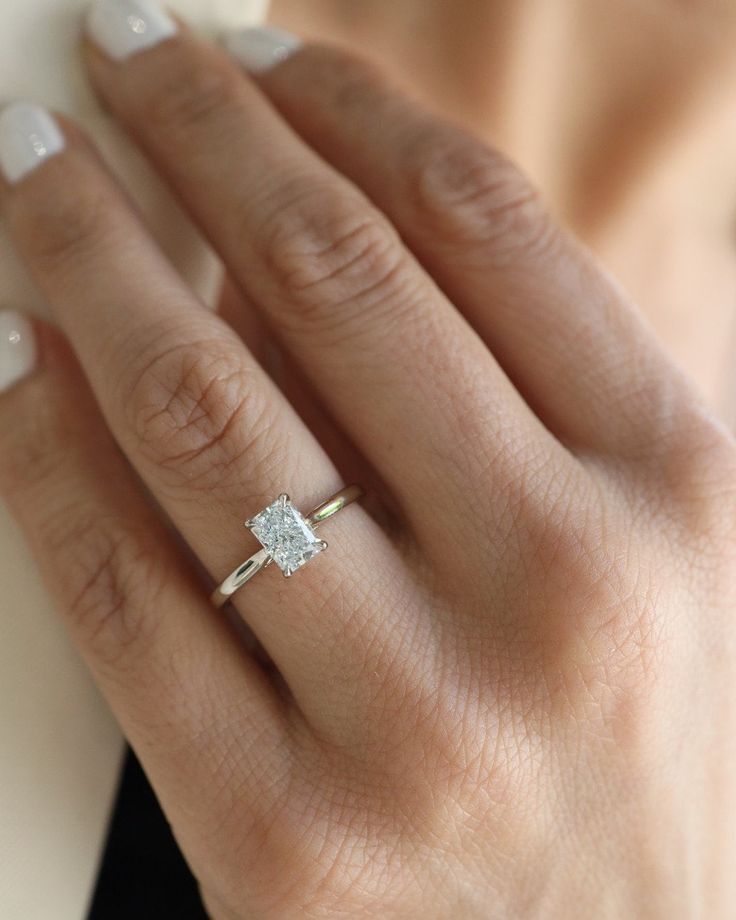 a woman's hand with a diamond ring on it