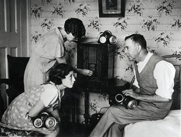 an old photo of three people in a living room