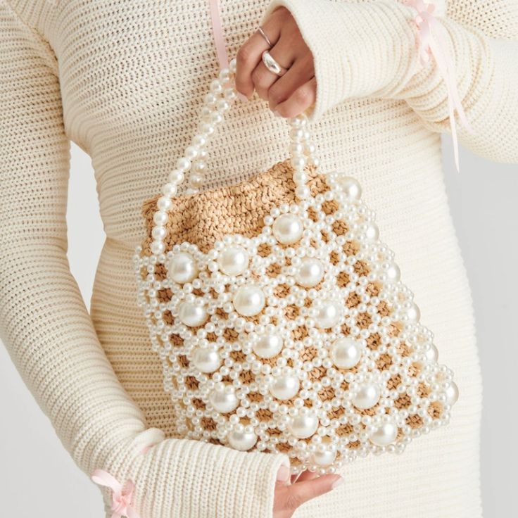 Crotchet And Pearl In One Bucket Bag, The Combo You Didn't Know You Needed. This Elegant And Unique Purse Provides An Outer Layer Covered In Small And Large Pearls, While The Raffia Insert Keeps All Your Belongings Safe And Secure.&Nbsp; Dimensions: 7.8" L X 2" W X 10" H Drop= 9" Raffia And Synthetic Pearl + Raffia Trim Handmade Crochet Raffia Pouch + Hand Strung Pearl Detailing Drawstring Closure Elegant White Woven Crochet Bag, Elegant White Handwoven Bag, White Vacation Bag With Pearl Handle, Elegant White Crochet Bag For Shopping, Elegant White Crochet Tote Bag, Elegant Crochet Bag For Spring Evenings, Elegant Handwoven Crochet Bag For Spring, Elegant Crochet Evening Bag For Spring, Elegant Evening Crochet Bag For Spring