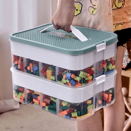 a person holding a plastic container filled with legos