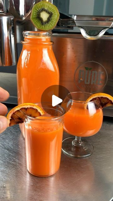 two glasses filled with orange juice sitting on top of a counter