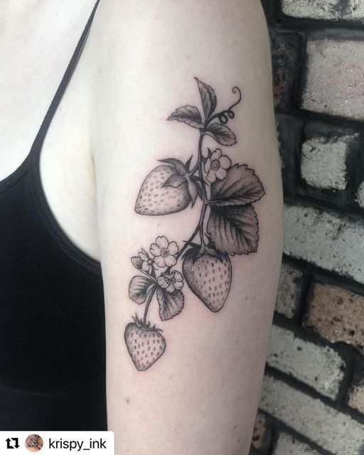 a black and white tattoo of strawberries on the arm