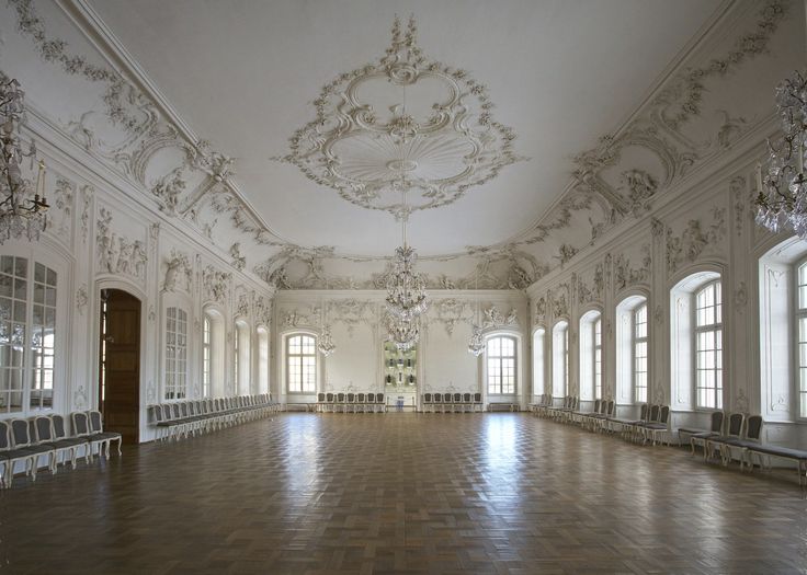 an empty ballroom with chairs and chandeliers