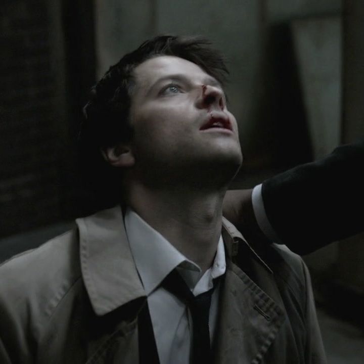 a man in a trench coat and tie looking up into the sky with his eyes closed