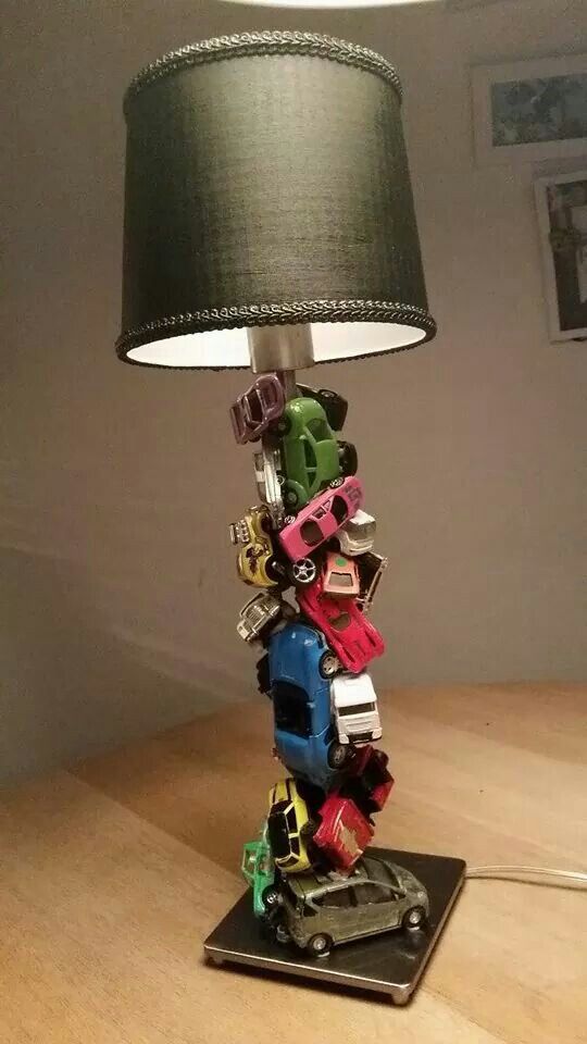 a lamp that is sitting on top of a table with cars and trucks all over it