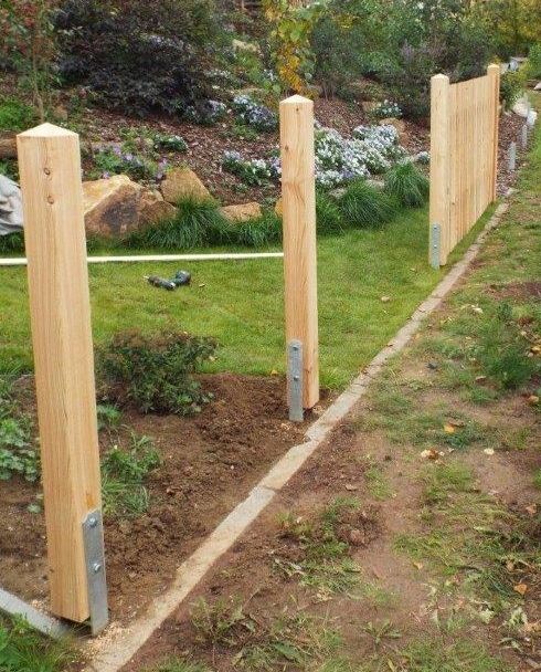 three wooden posts are standing in the grass