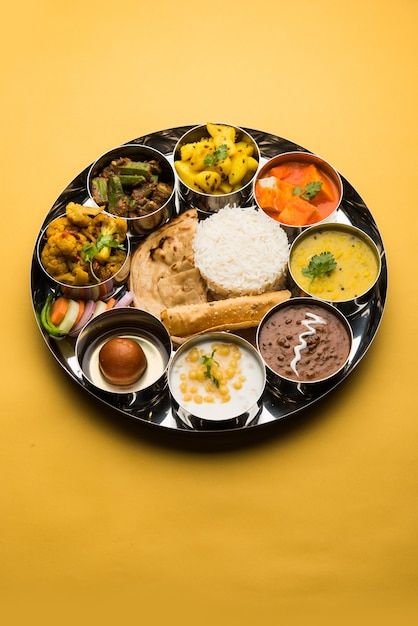 a black plate filled with different types of food on top of a yellow tablecloth