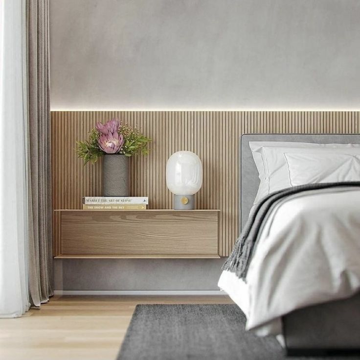 a bedroom with a bed, nightstand and flower pot on the end table in front of it