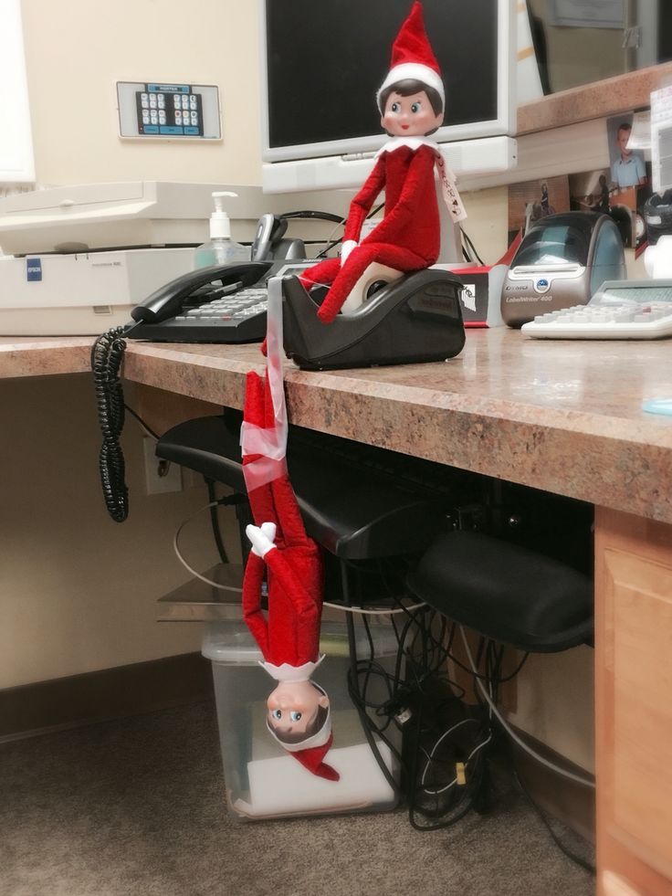 an elf sitting on top of a computer desk