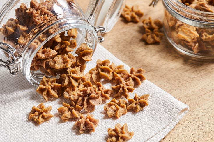 a glass jar filled with dog food on top of a wooden table