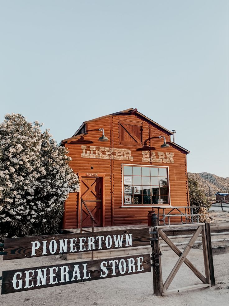 an old wooden building with a sign in front of it that says pioneers general store