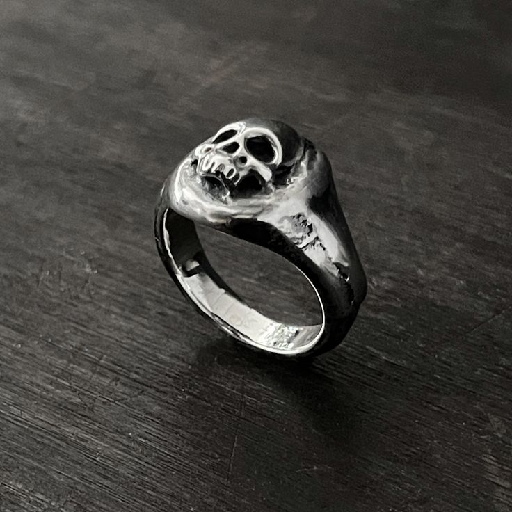 This skull ring is perfect for the macabre person in your life. This solid oxidised 925 sterling silver signet ring features a melted skull design. Solid oxidised 925 sterling silver signet ring featuring a melted skull design. Top of ring measures 1.3cm x 1.3cm 925 Oxidised Sterling Silver Each piece is handmade to order in the Jewel Thief Brighton atelier. Gothic Skull Rings With Engraving, Symbolic Skull Rings For Halloween, Halloween Skull Rings Symbolic Style, Halloween Skull Print Rings, Gothic Skull Ring With Polished Finish Gift, Gothic Skull Ring With Polished Finish, Hand Cast Black Skull Ring, Black Hand Cast Skull Ring Gift, Halloween Engraved Skull Ring Gift