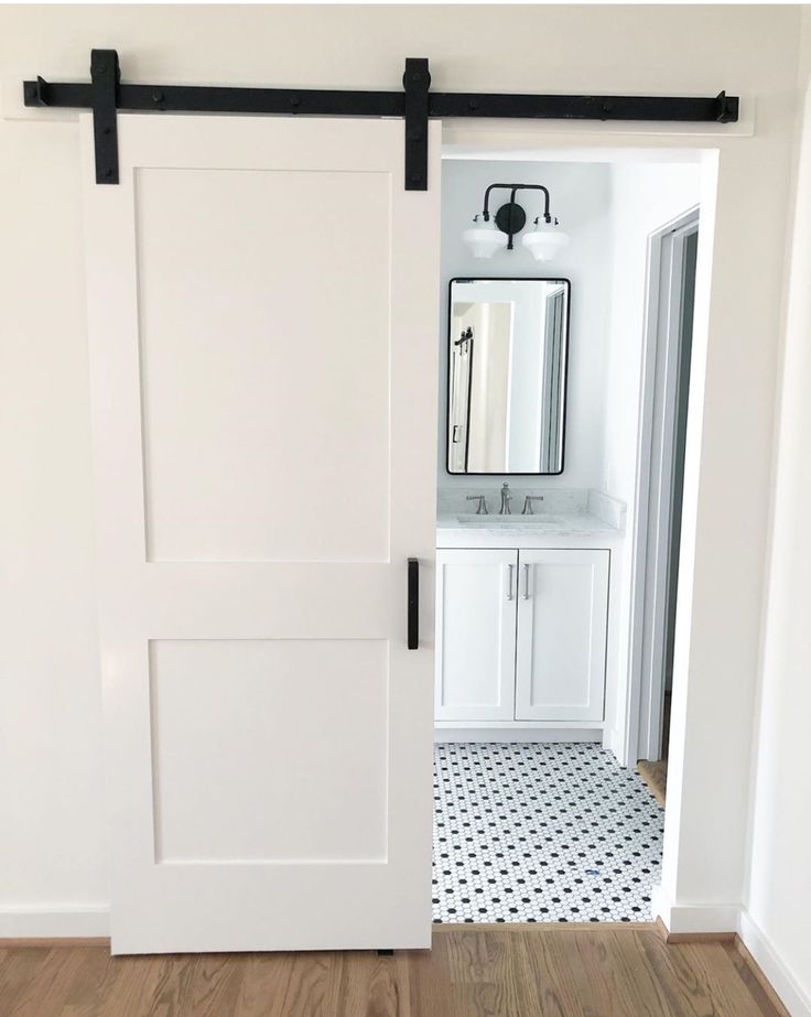 an open white barn door in a bathroom