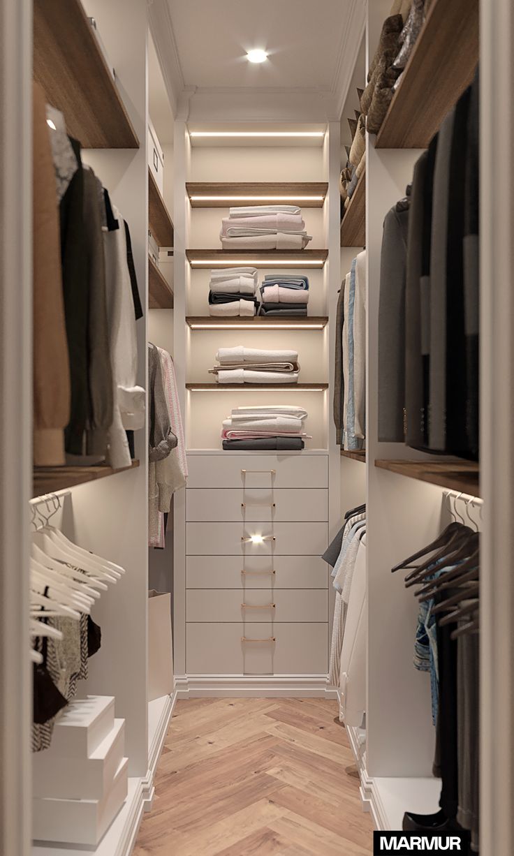 a walk - in closet with shelves, drawers and clothes on hangers that are open