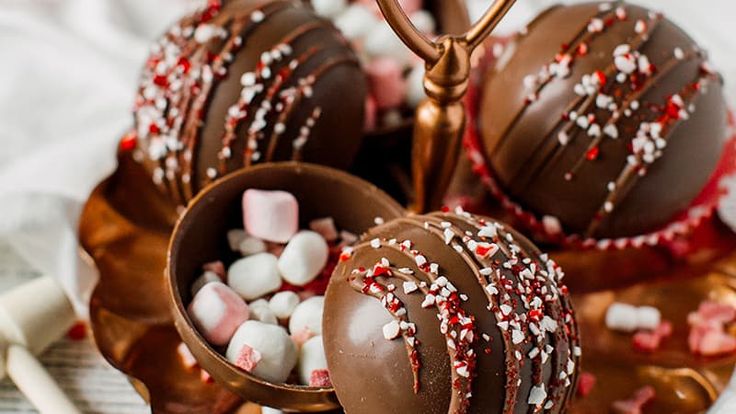 chocolate covered candies with sprinkles and marshmallows on a plate