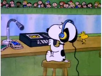 a cartoon dog with headphones on sitting in front of a desk and listening to music