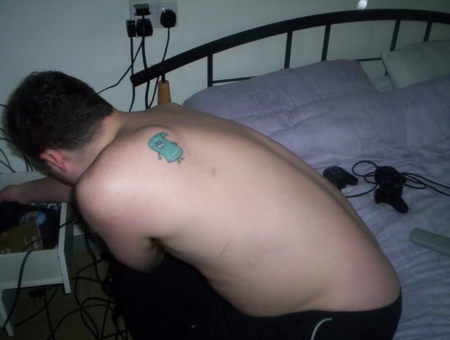 a man with an elephant tattoo on his arm leaning over a bed in a bedroom