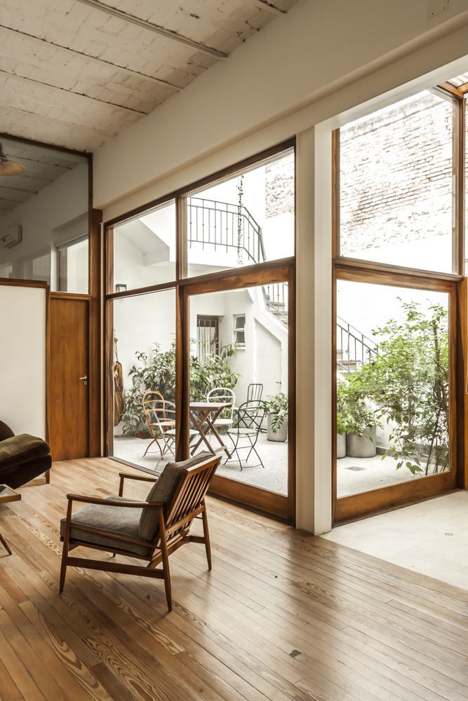 a living room with wooden floors and large windows