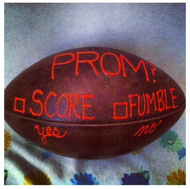 a close up of a football on a bed with the words prom and score written on it