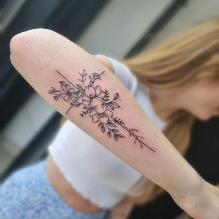 a woman's arm with a flower tattoo on the back of her left arm