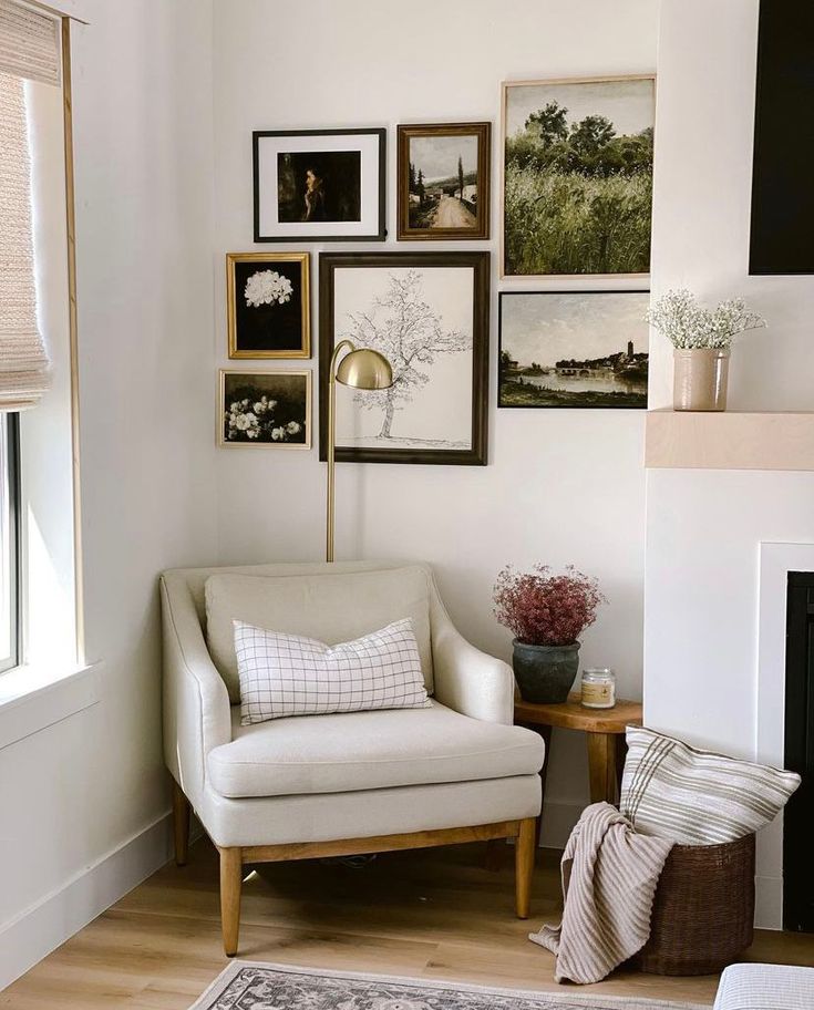 a living room with pictures on the wall and a chair next to a fire place