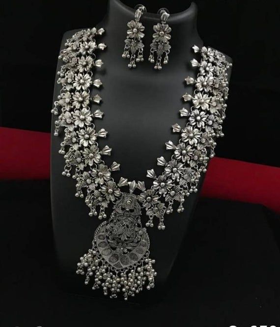 Add style  and charisma to your beautiful personality with this exquisitely designed and  handcrafted German Silver and oxidised alloy necklace   .Pair it up with any casual, semi formal or, formal attire and gather compliments for your unique and classy choice. Ideal wear for both casual and dressy occasionsLength 28-30 inches  with an adjustable black dori at the backWeight 154 GM's Earrings are lightweight*************************************Note: All in stock items will be shipped from New D Silver Bohemian Bridal Necklace, Festive Silver Alloy Jewelry, Silver Temple Jewelry Style Bridal Necklace, Traditional Oxidized Finish Necklace For Party, Handmade Silver Kundan Necklace, Silver Metal Bridal Necklace In Temple Jewelry Style, Traditional Sterling Silver Necklaces For Party, Festive Silver Metal Bridal Necklace, Silver Traditional Temple Necklace For Parties