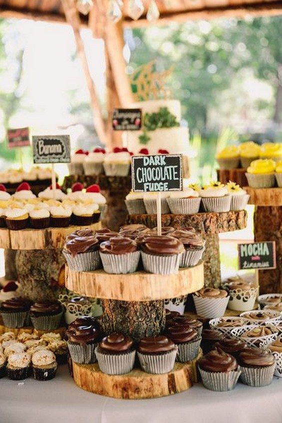 a table topped with lots of cupcakes covered in frosting and toppings