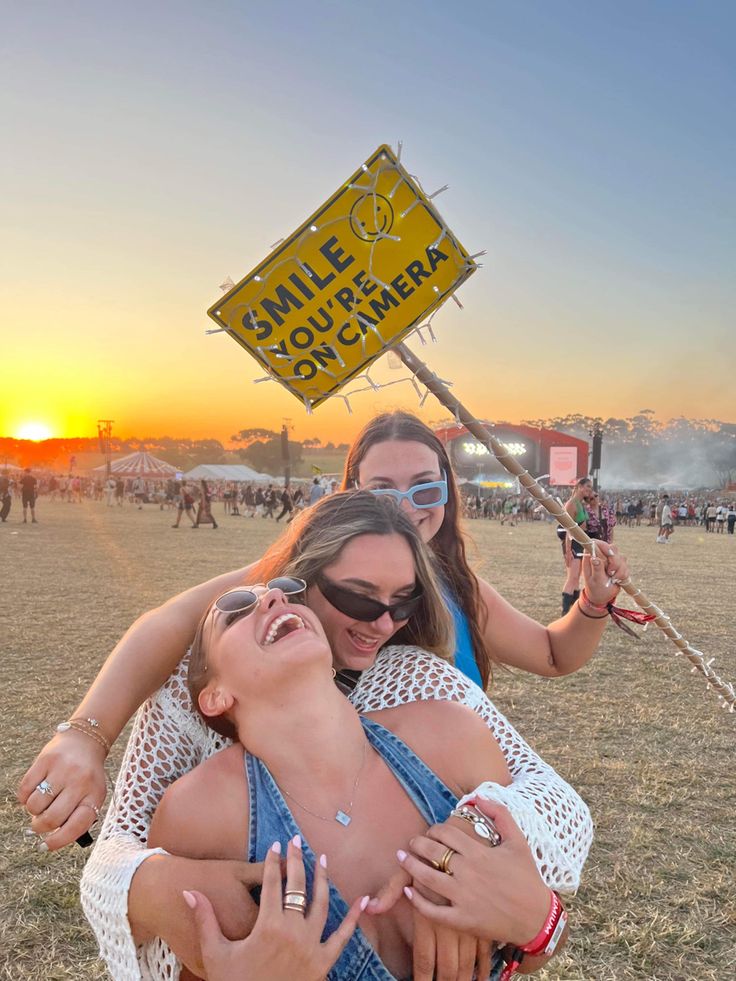 two women hugging each other in front of a sign